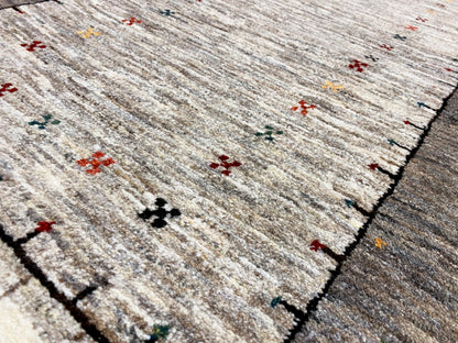 Gabbeh runner rug close-up: light pile with fine patterned crosses and a dark border