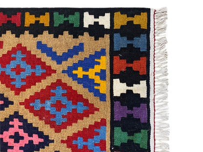 Kelim rug: edge detail with fringes and a colorful geometric pattern.