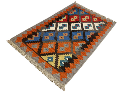 Flatweave rug with a geometric pattern, gray background, orange and blue diamonds, fringe