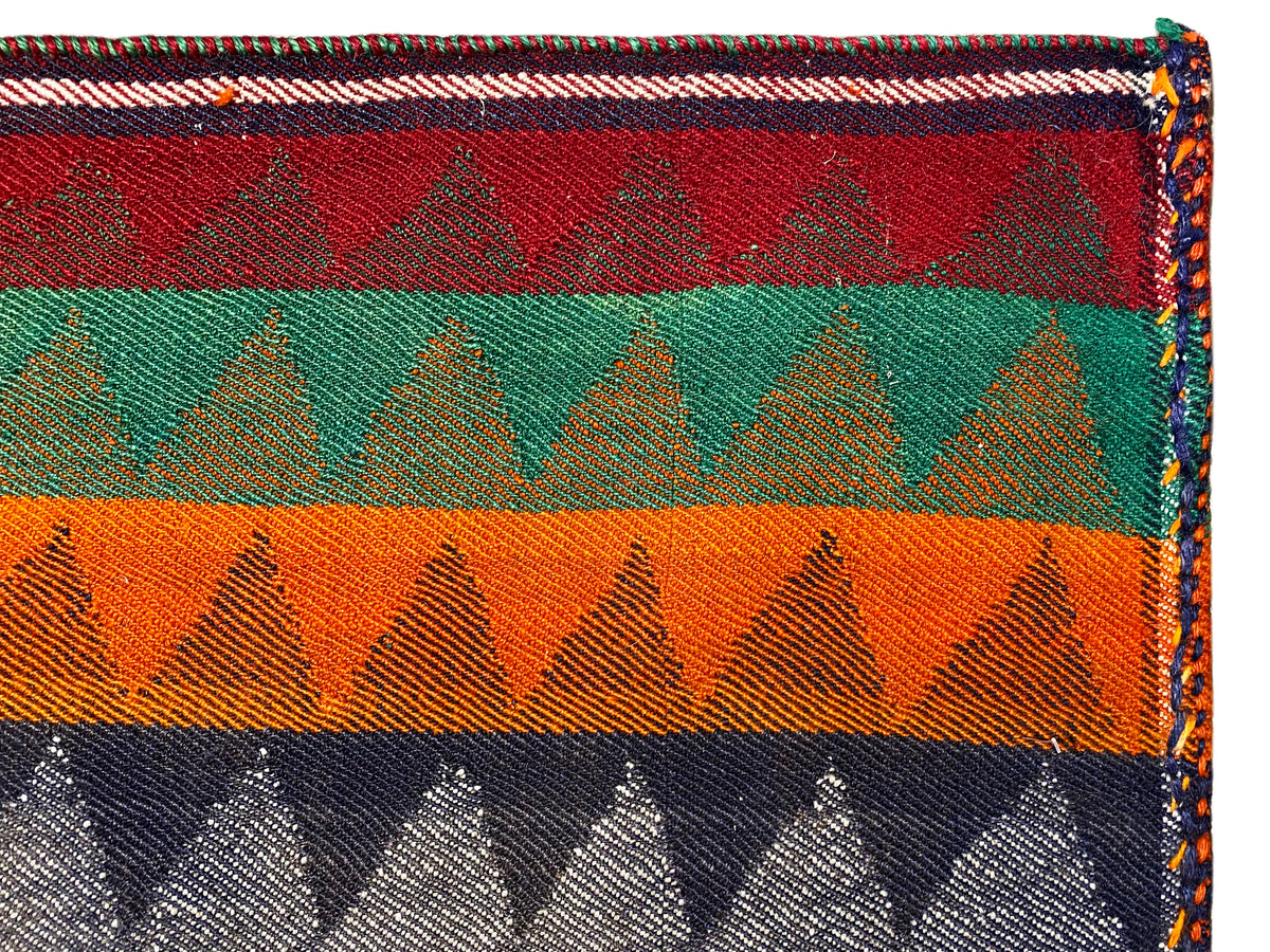 Jajim runner rug detail: multicolored stripes, zigzag pattern, bound edge