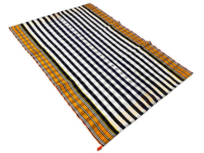 Jajim rug spread diagonally with a black-and-white striped pattern and orange border trim