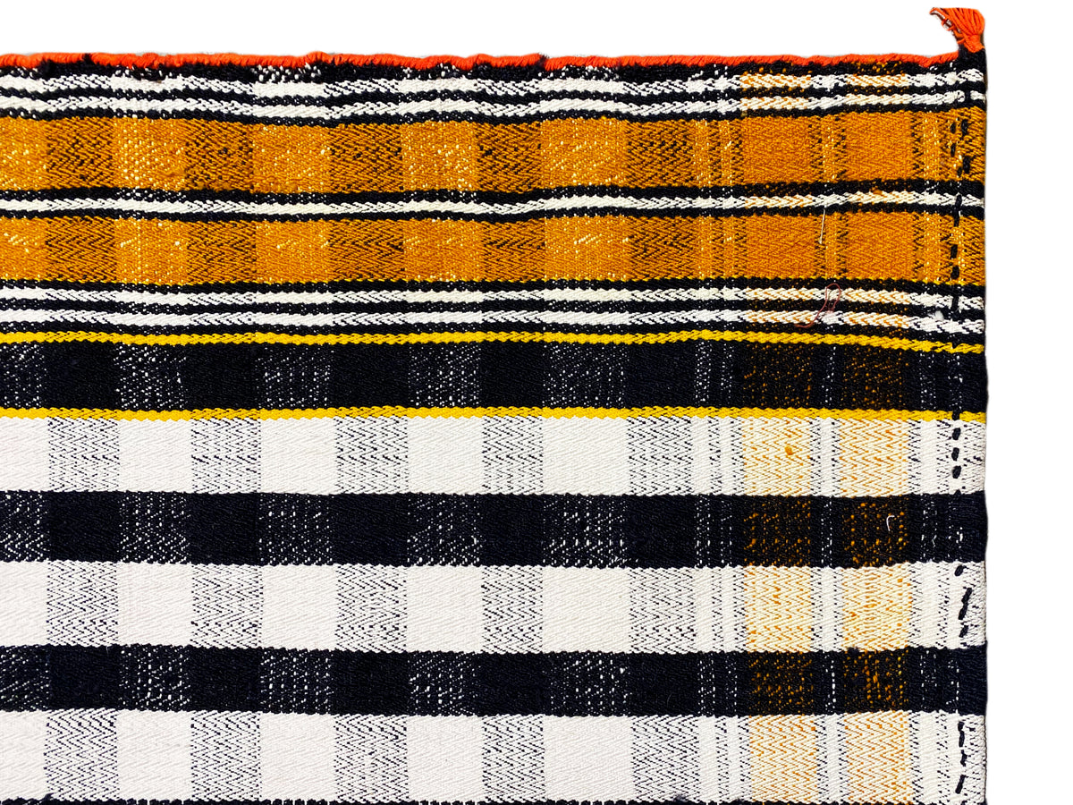 Jajim rug close-up of the stripes in black, white, and orange with fringes
