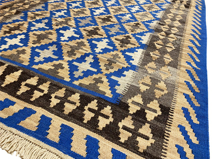 Kelim rug with a geometric pattern in blue, beige, and dark brown, with fringes