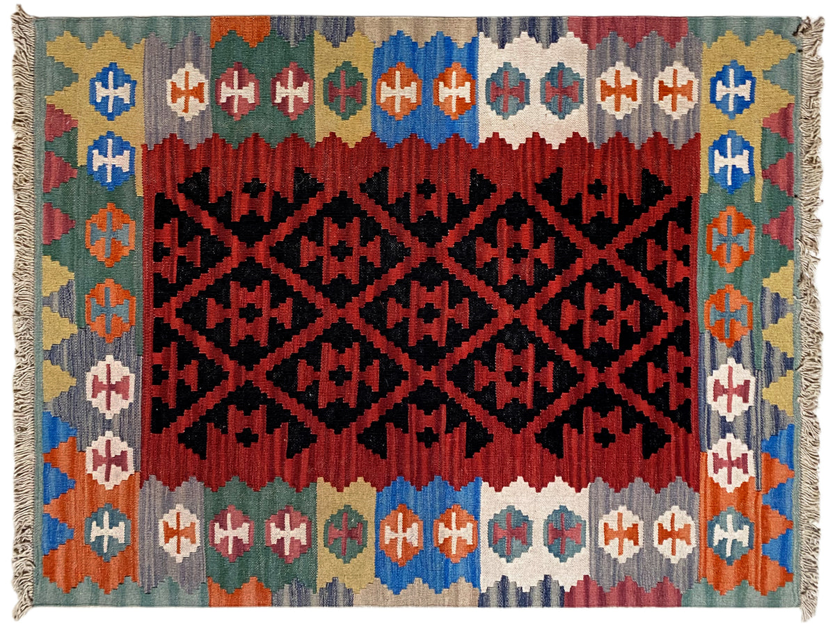 Kilim rug with a rectangular pattern in black on red, a colorful border, and fringes