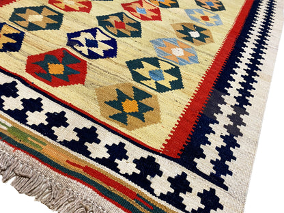 Kelim-Qashqai rug in beige with a geometric pattern and fringes along the edge, close-up