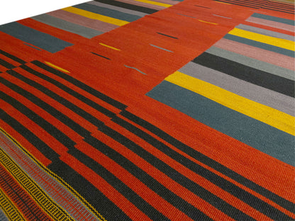 Kelim-Teppich Detail: orange-rote Fläche mit schmalen Streifen und bunten Rechtecken