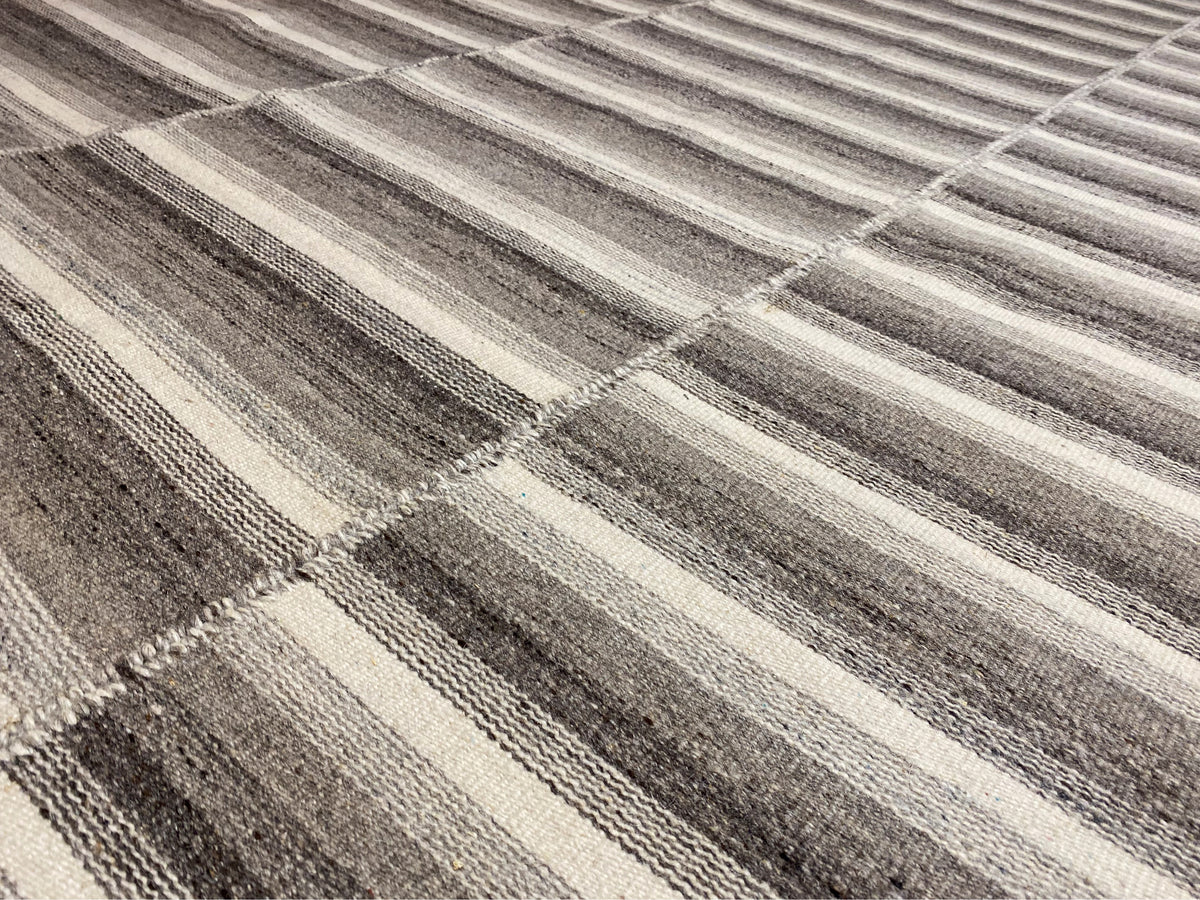 Kelim Teppich Detail: gesprenkelte Streifen und Karos in Grau und Weiß