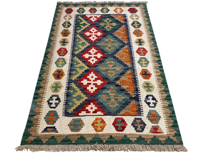 Kilim rug with a large diamond border, colorful blocks of color, and fringes