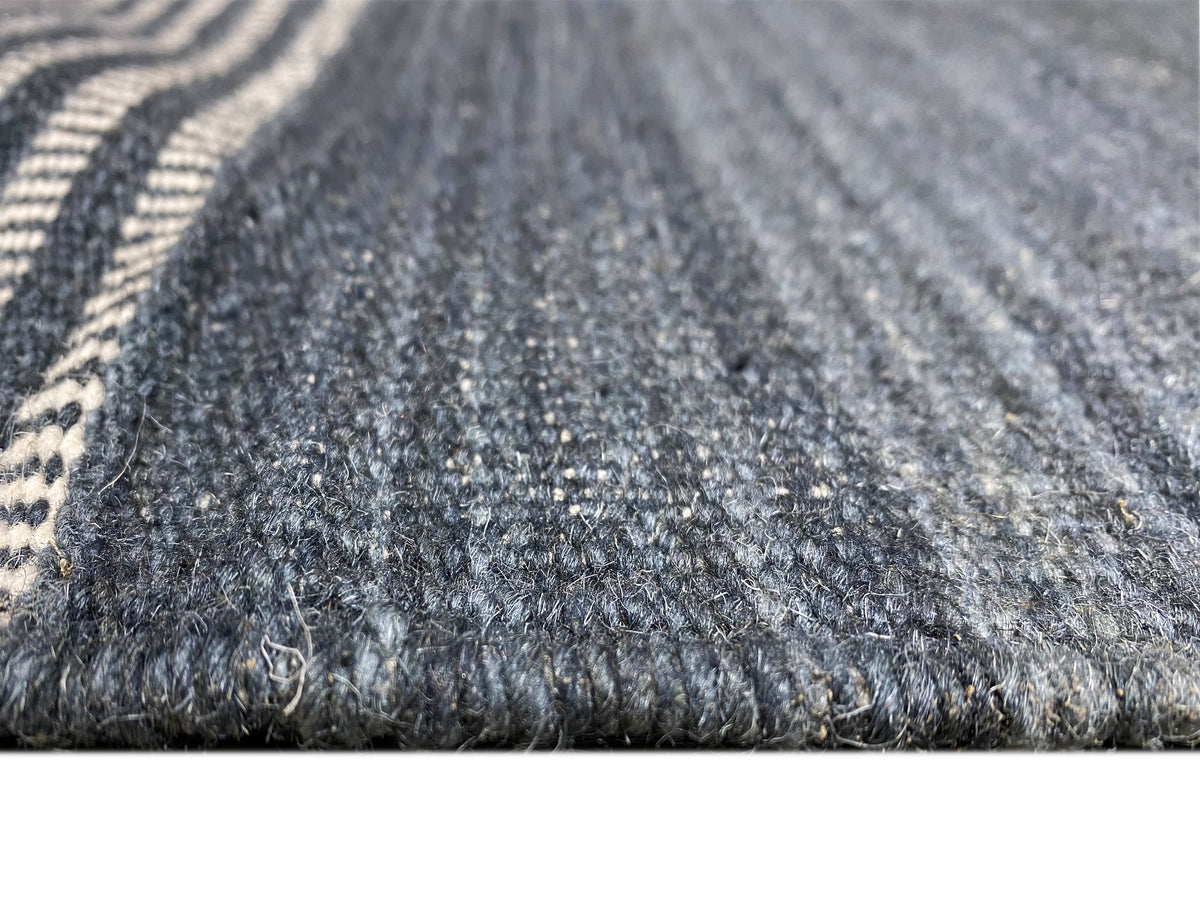 Kelim Teppich Nahansicht: blau-grauer Flor mit feinen weißen Linien im Gewebe