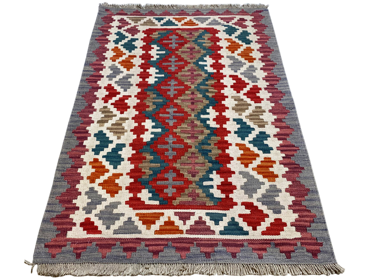 Rectangular kilim rug with a large geometric pattern in red, blue, green, and white