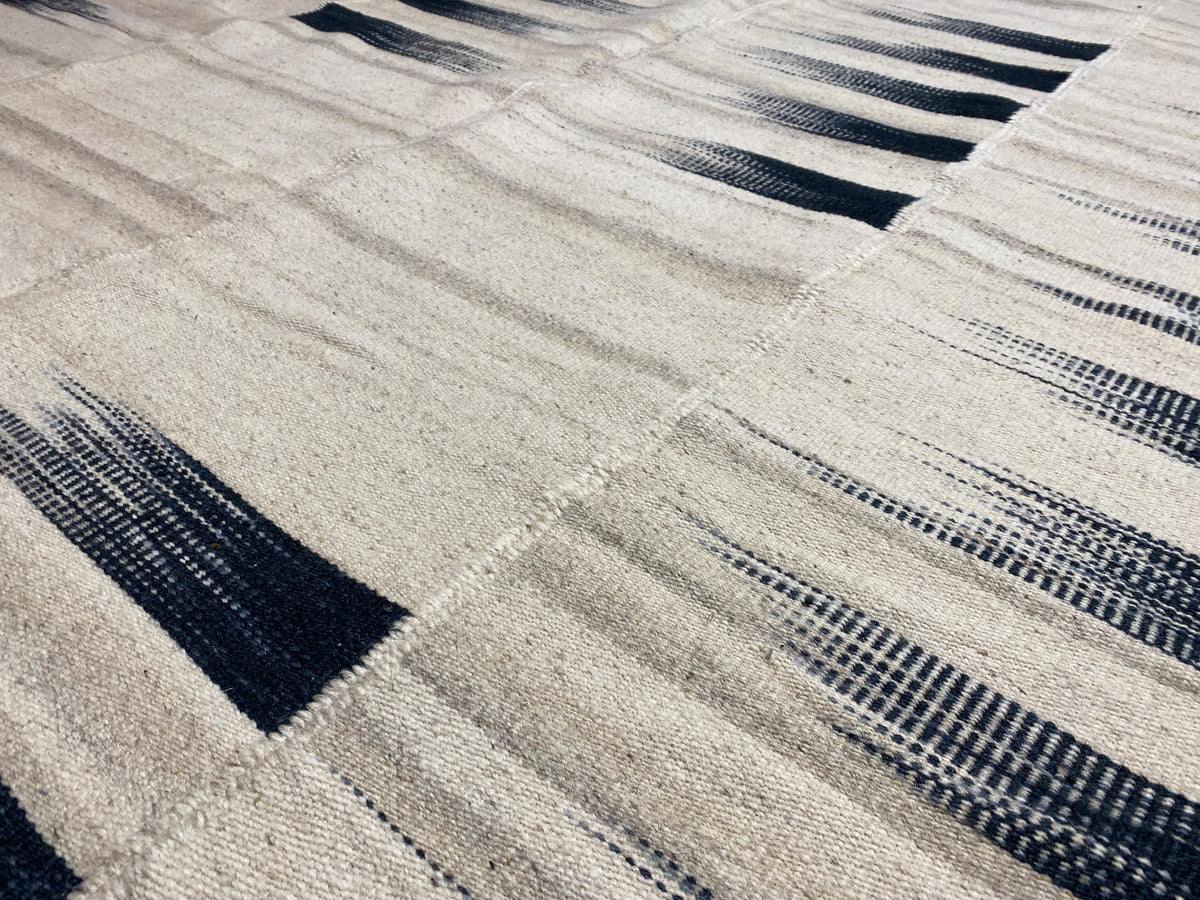Kilim rug 170x240 cm close-up: cream-colored tiles with dark blue bars