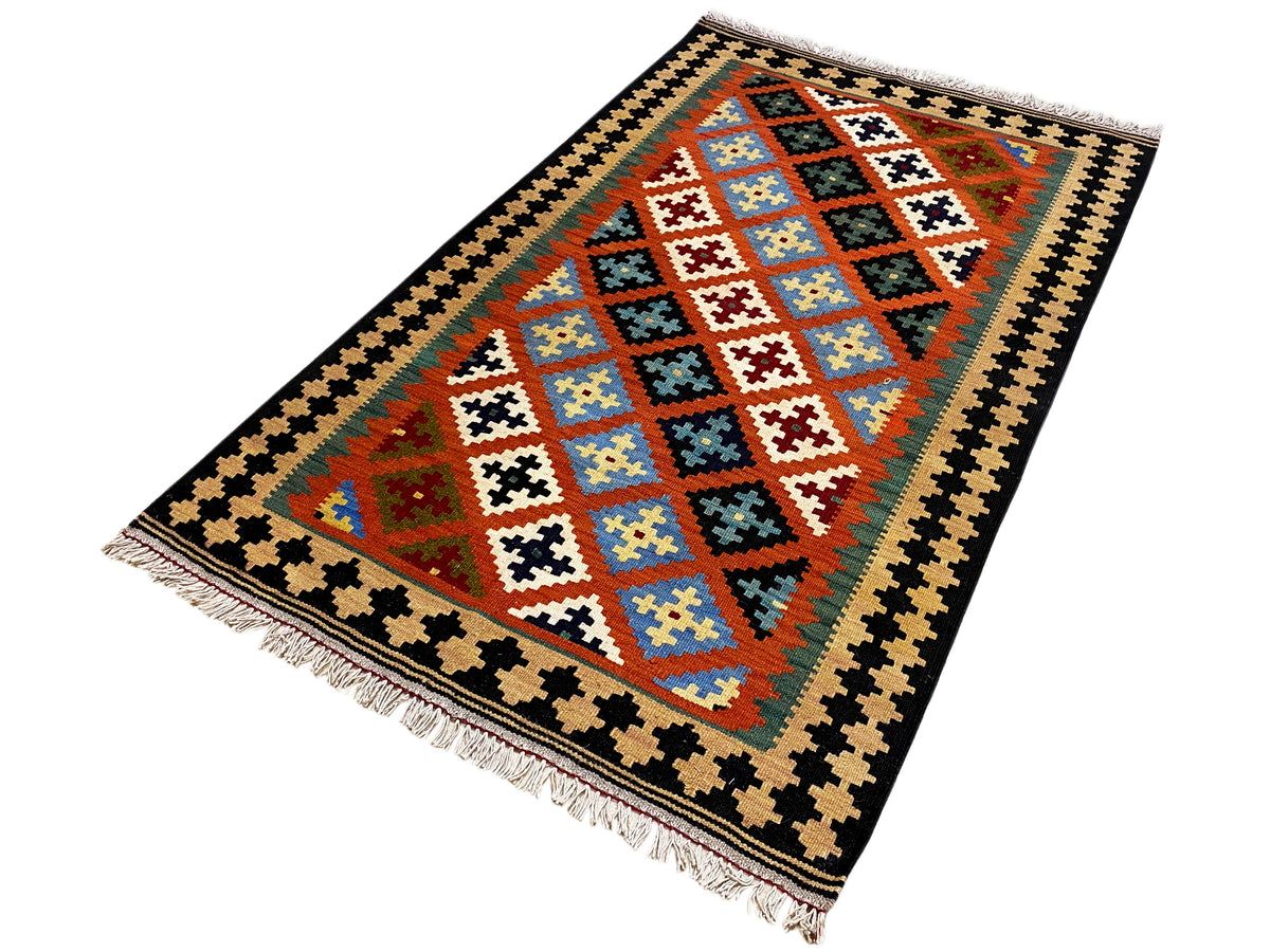 Colorful kilim rug with geometric sections and fringes, black zigzag border