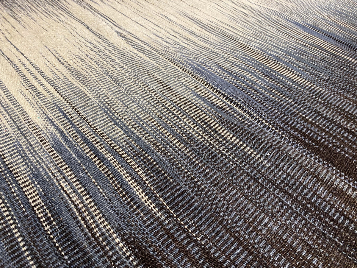 Kelim-Teppich Detail: feine Linien in Blau-grau und Creme, zentrierte Streifenstruktur