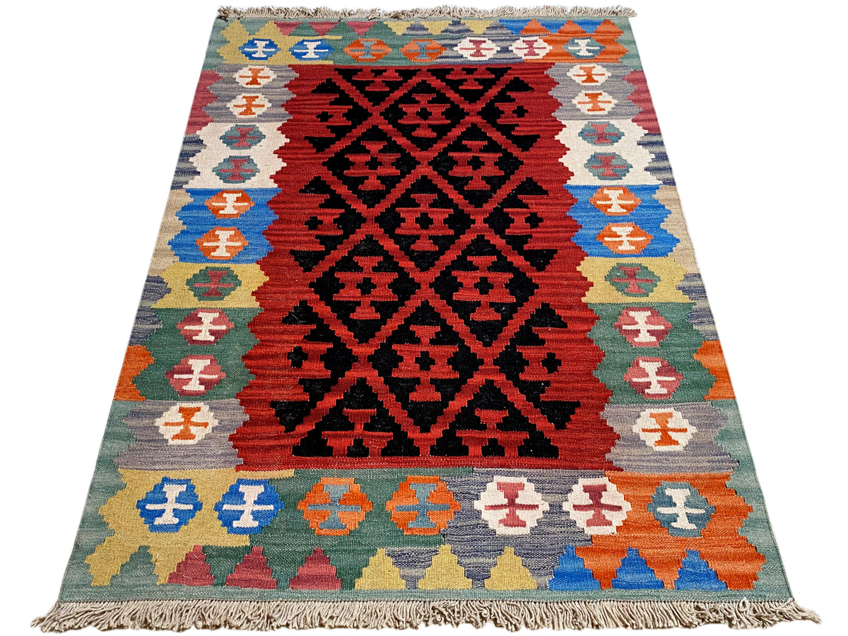 Kilim Qashqai rug with a red central field, surrounding pattern, and fringes