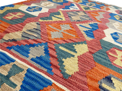 Close-up: Qashqai kilim rug with multicolored diamond patterns and fringed edges