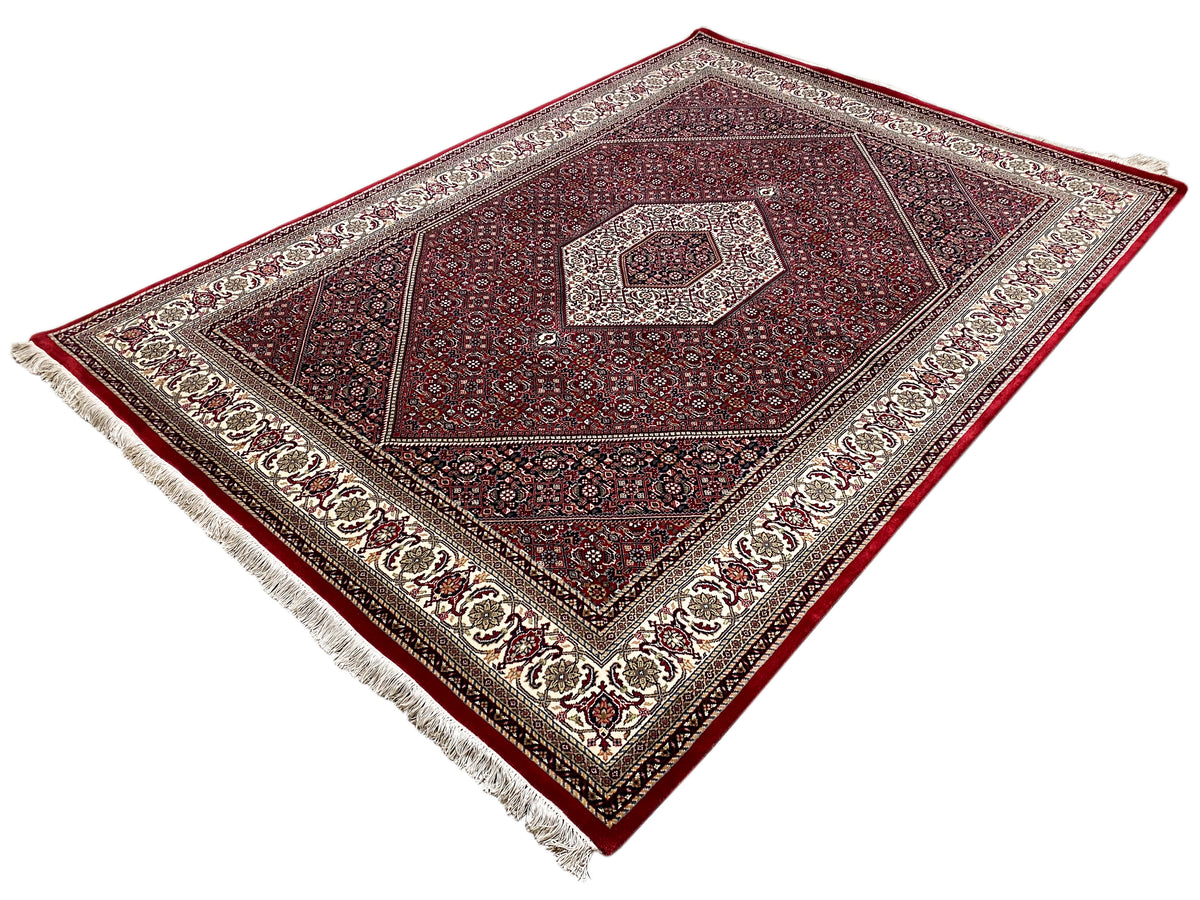 Red Bidjar rug with a symmetrical pattern and fringes along the edge
