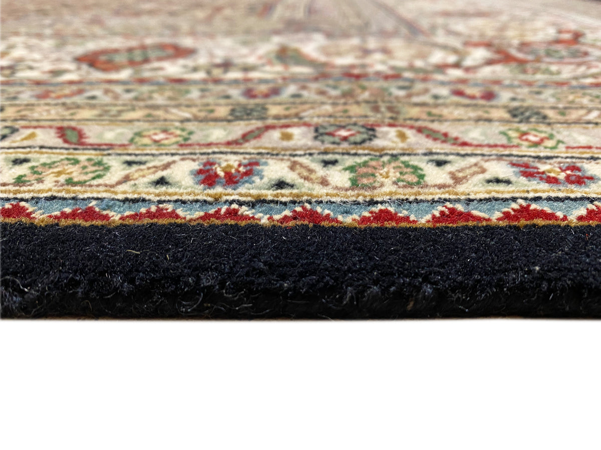 Close-up of the carpet edge with dark pile and a colorful border stripe