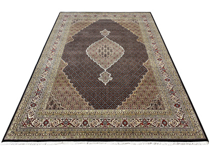 Oriental rug in shades of gray and blue with a dark brown medallion and ornamental border