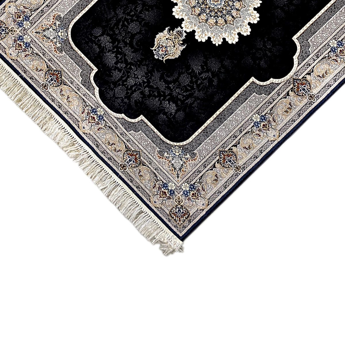 Close-up of a corner: black rug with an embossed ornamental border, cream, blue, and fringes