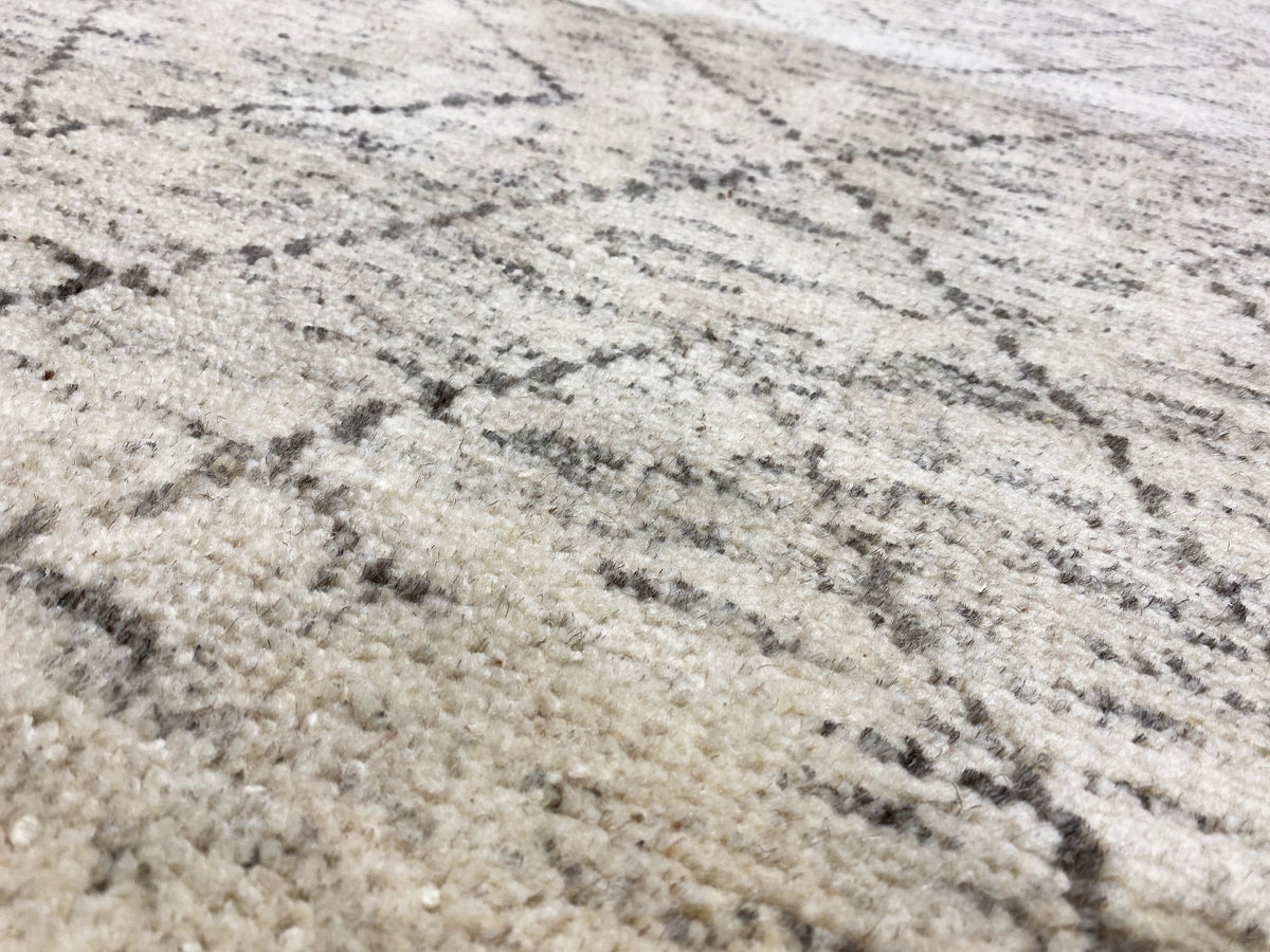 Close-up: Berber rug with mottled pile and dark gray linear pattern