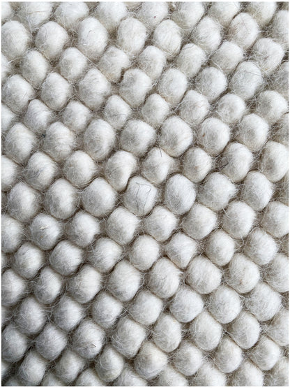 Carpet, close-up: dense wool balls in a grid, light gray/white