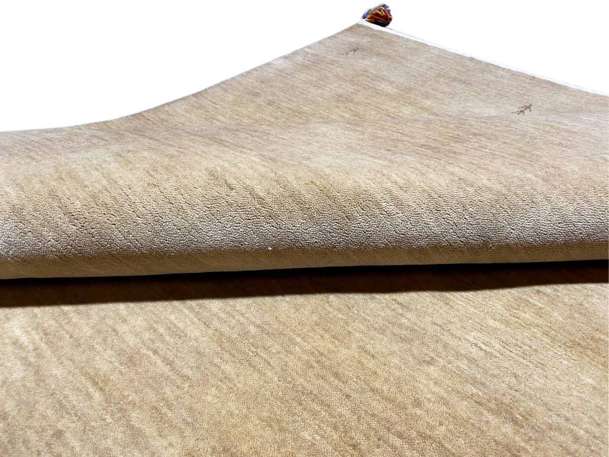 Gabbeh rug in light brown, close-up of the edge with a white border and fine texture
