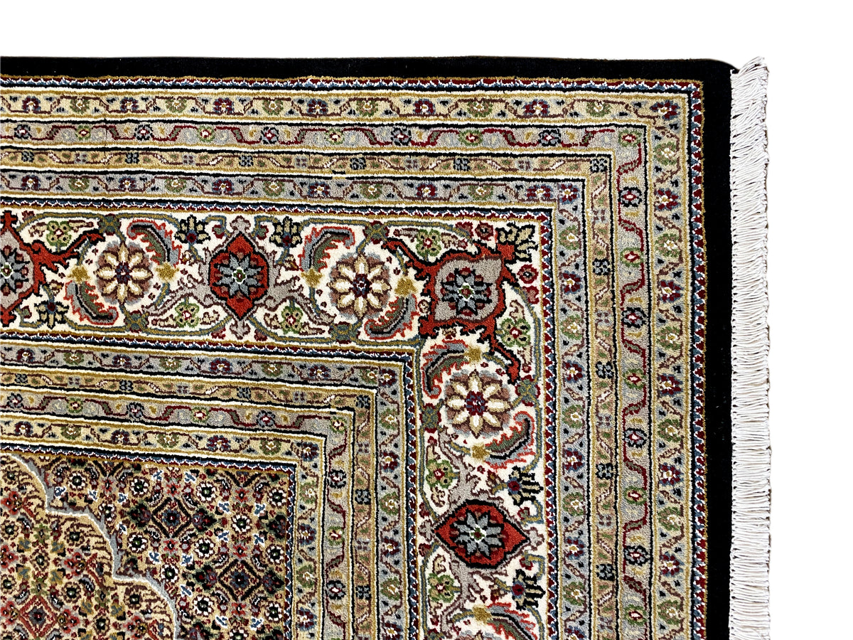 Rug detail with multicolored ornamental elements and fringes along the edge