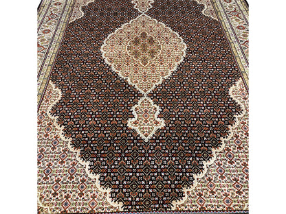 Brown Indo-Tabriz rug detail: fine pattern in the dark field with a light center