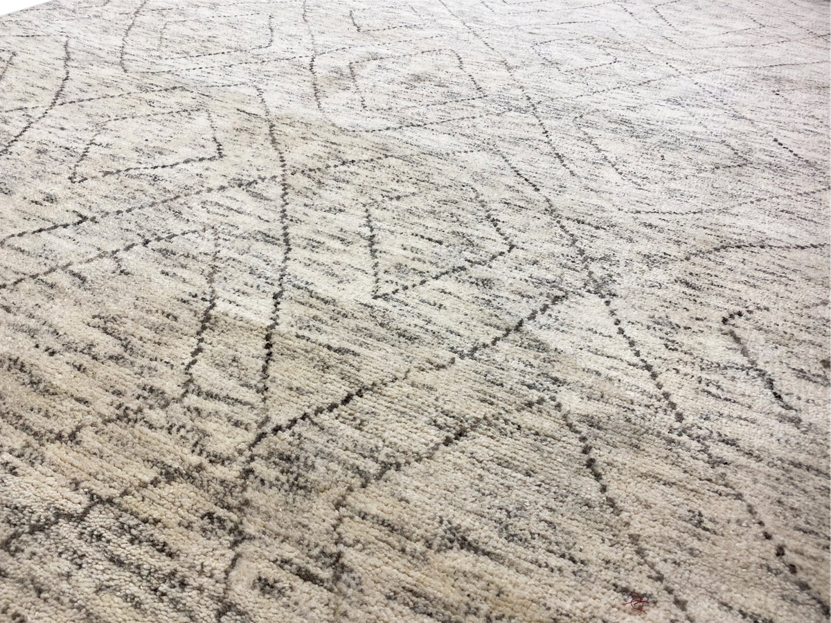 Close-up: light beige Berber rug with fine dark gray lines and a woven texture