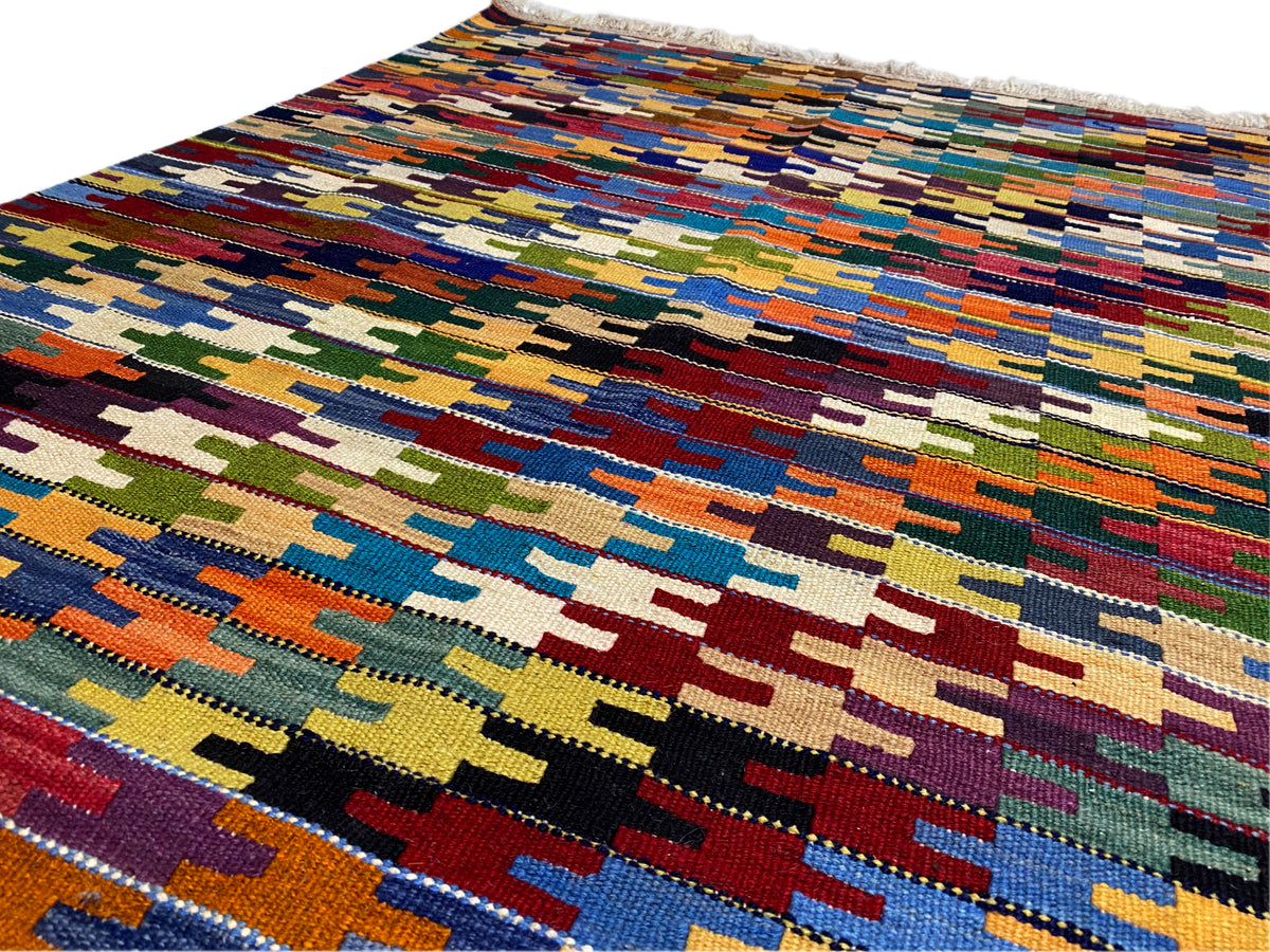 Detail of the Kelim Qashqai rug: multicolored patterned bands, fine woven texture
