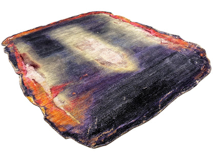 Designer rug with an irregular shape and abstract interplay of dark blue, purple, cream, and orange.