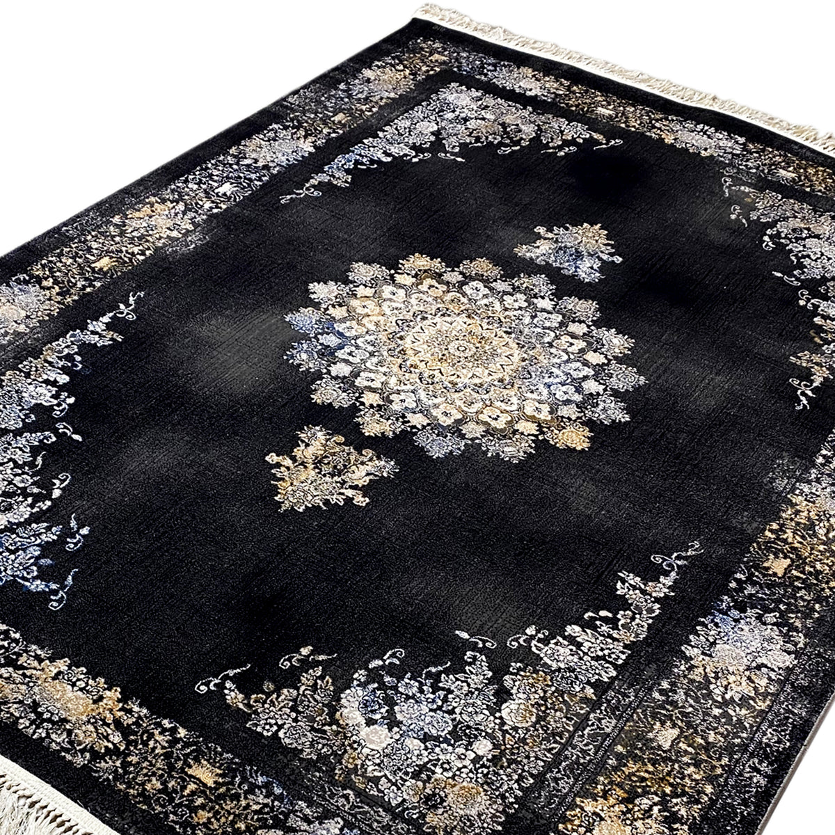 Black rug with a geometric medallion design in cream and gold, fringes