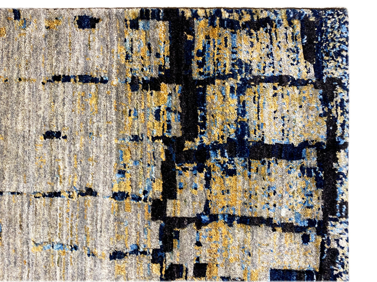 Hand-knotted rug detail: light gray with a blue and yellowish tile pattern