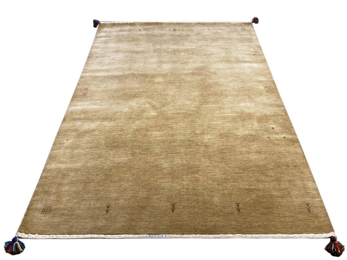 Light brown Gabbeh rug with a white border and blue tassels at all four corners