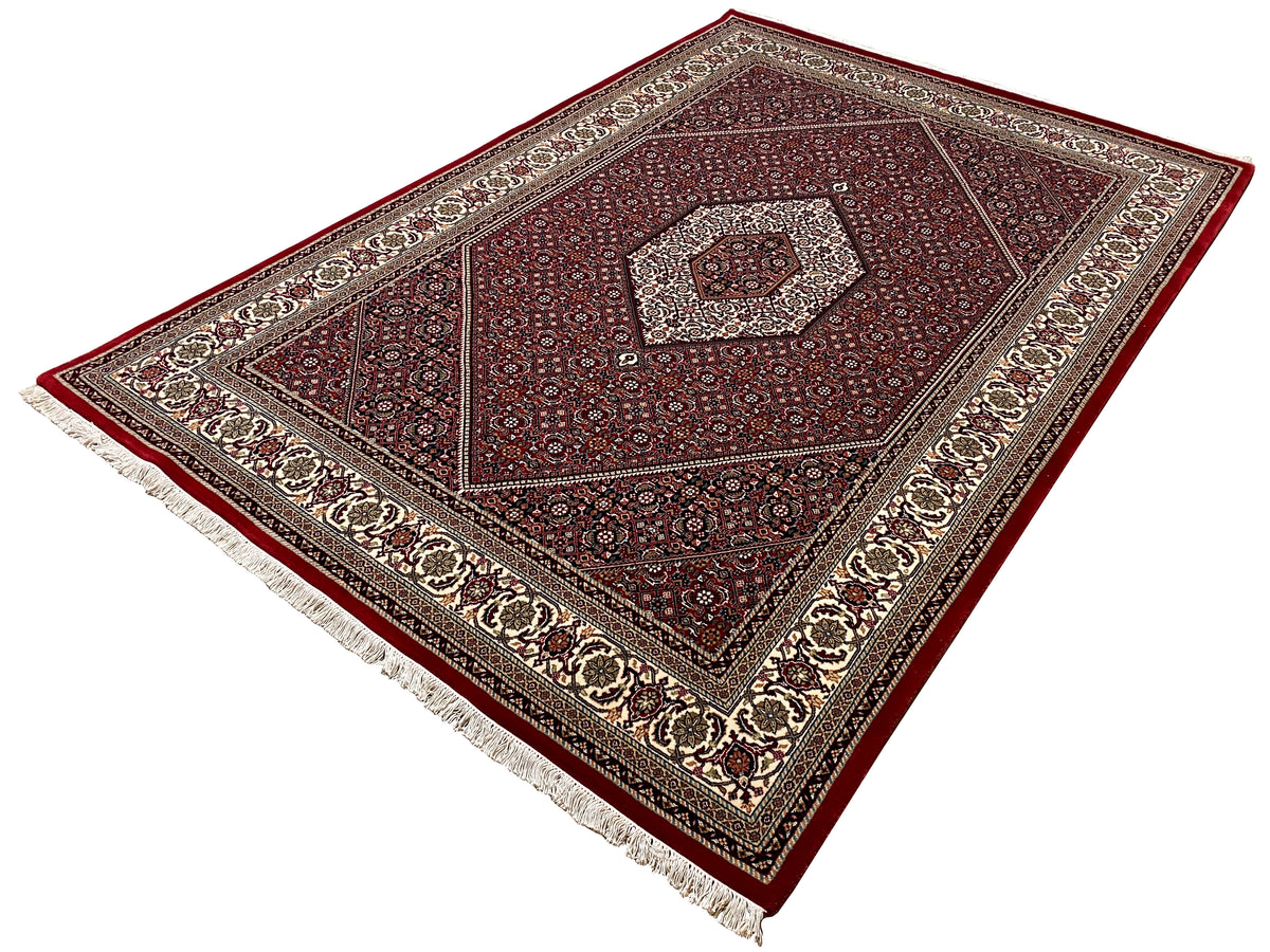 Rug 244x170 cm shown at an angle: red medallion pattern with fringes