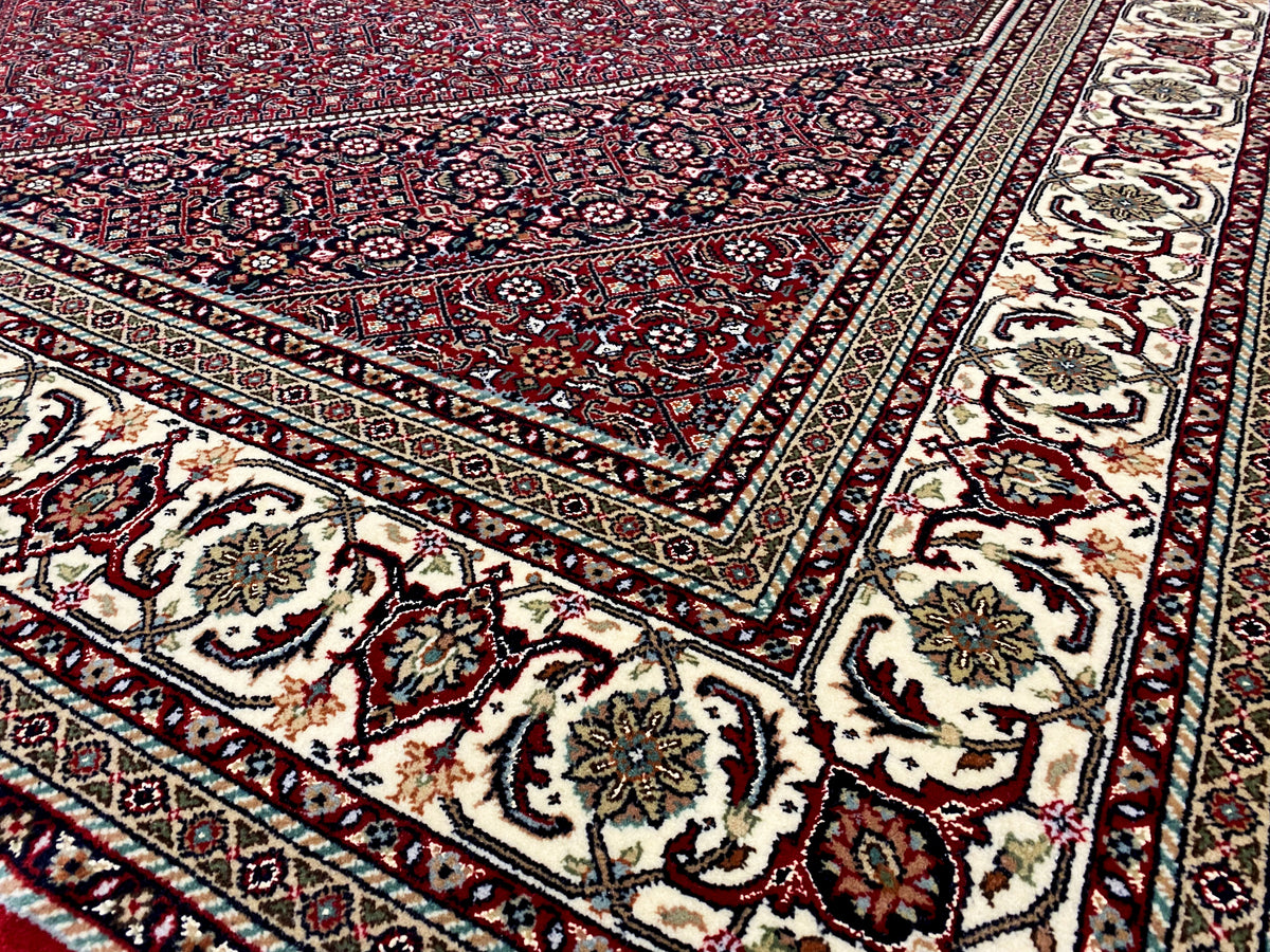 Close-up of a Bidjar rug: red field with delicate ornaments, cream-colored border band