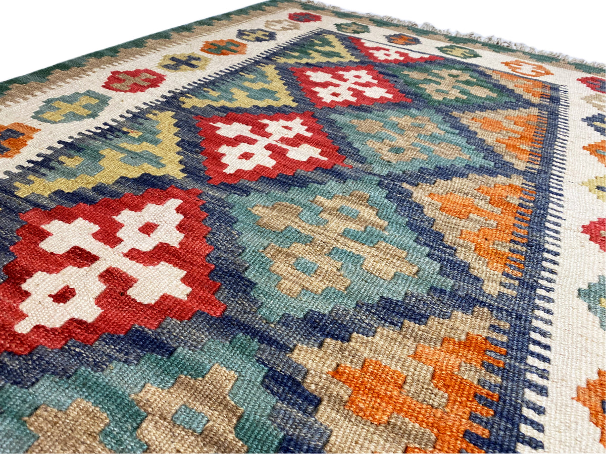Detailed view of kilim rug: colorful diamonds, edge border, and felted texture