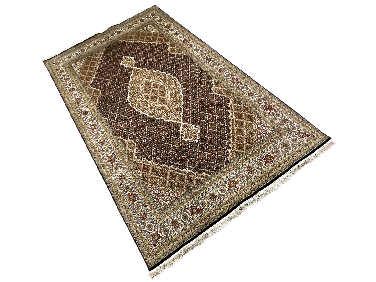 Brown Indo-Tabriz rug in detail: central medallion, fine border, fringe.