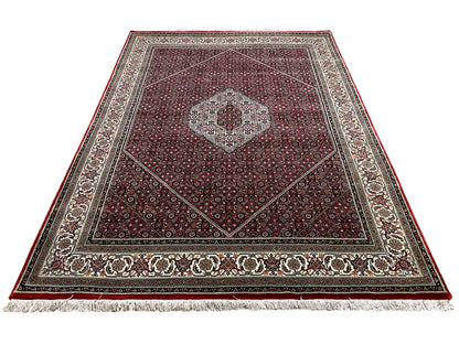 Bidjar rug at an angle: reddish-brown ground pattern with a central medallion and decorative border