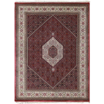 Red rug with a central medallion and surrounding border in cream and dark blue