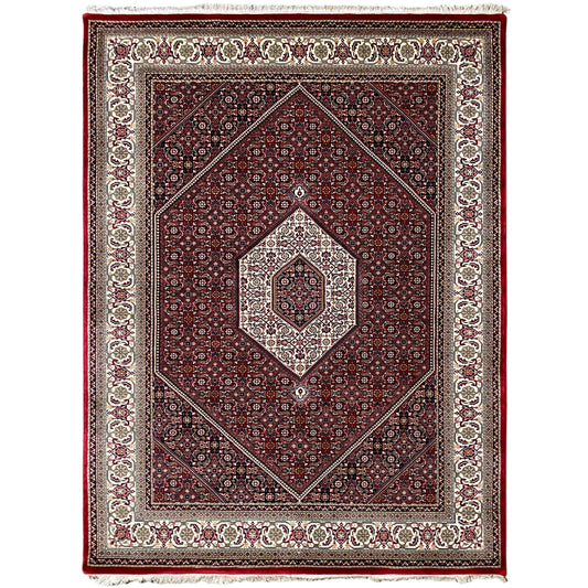 Red rug with a central medallion and surrounding border in cream and dark blue