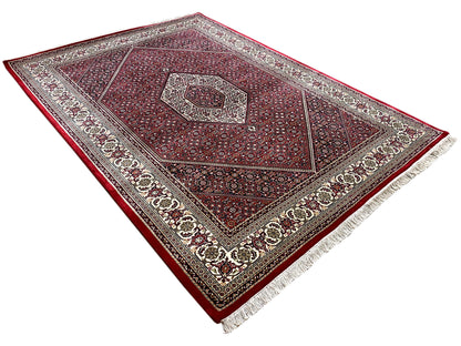 Red carpet seen at an angle with a central medallion and surrounding decorative border