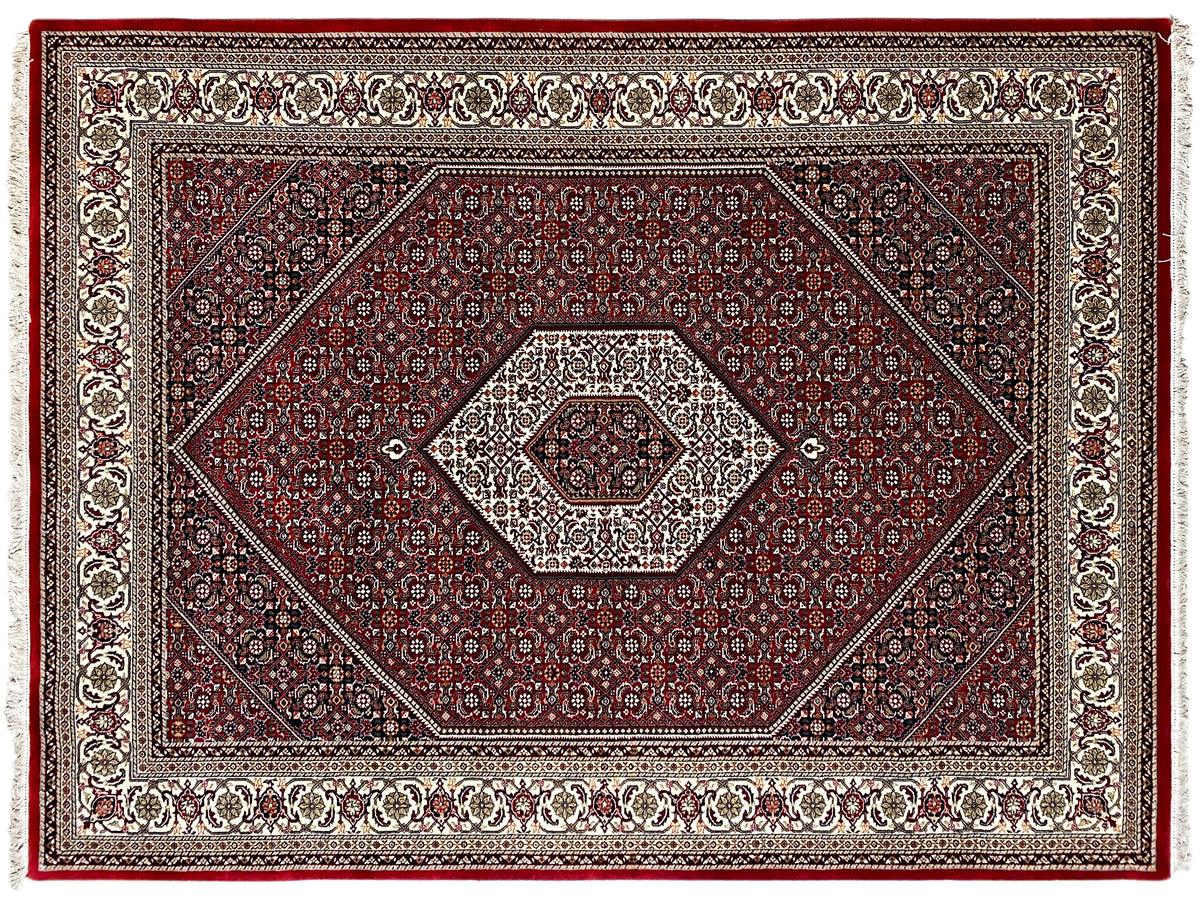 Close-up of the red carpet: diamond and ornamental patterns with decorative border, fringes