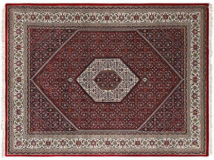 Close-up of the red carpet: diamond and ornamental patterns with decorative border, fringes