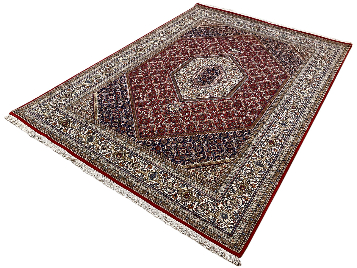 Rug with a red center, dark outer field, and ornamental fringed border