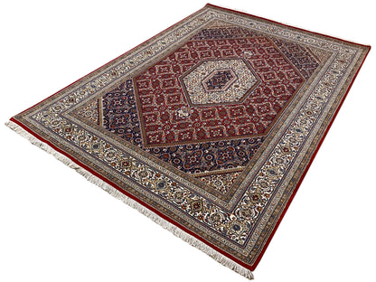 Rug with a red center, dark outer field, and ornamental fringed border