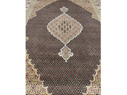 Close-up: beige and dark brown carpet medallion with a lively pattern, lower section