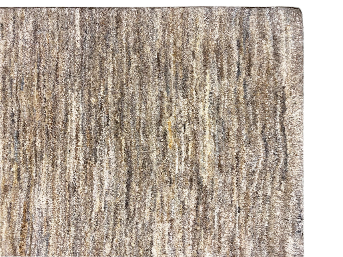 Gabbeh rug, close-up: mottled beige-gray striped texture and short pile