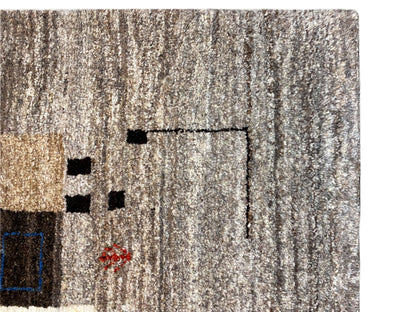 Close-up of the pile of a Gabbeh rug in light beige-gray with a linear pattern