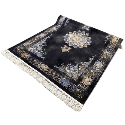 Black rug with geometric patterns in cream, blue, and gold, with fringes
